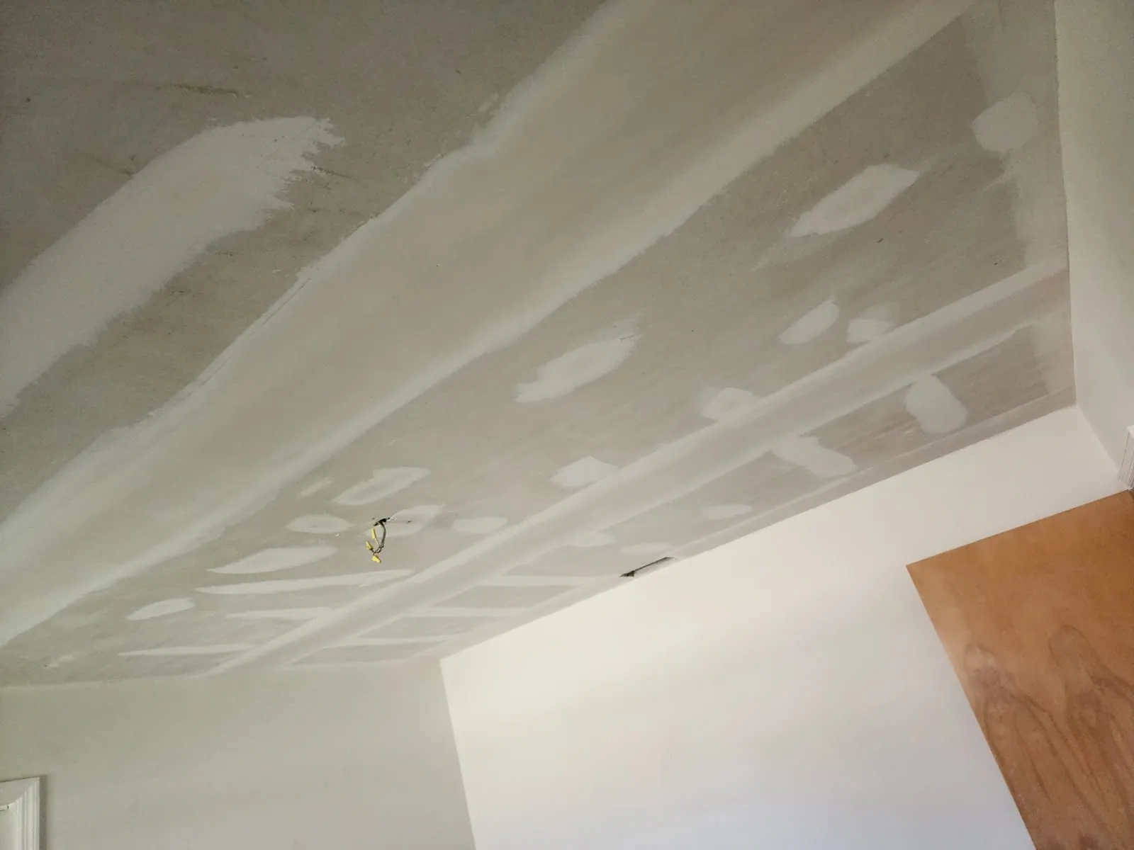 Ceiling repair in progress: seams taped and coated and fastener spots filled, before sanding and texture