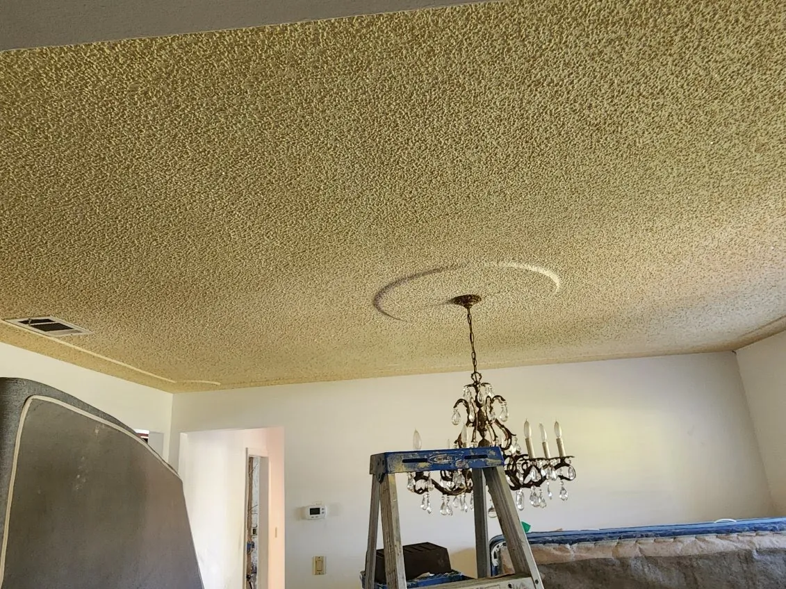 Popcorn ceiling around a crystal chandelier in an older Brevard County home